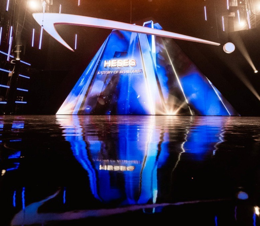HESEG event stage with blue lighting and reflective floor.