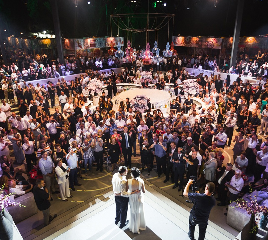 Couple on stage at a large outdoor event.