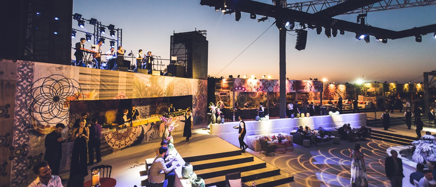 Panoramic outdoor event venue with live music and patterned decor.
