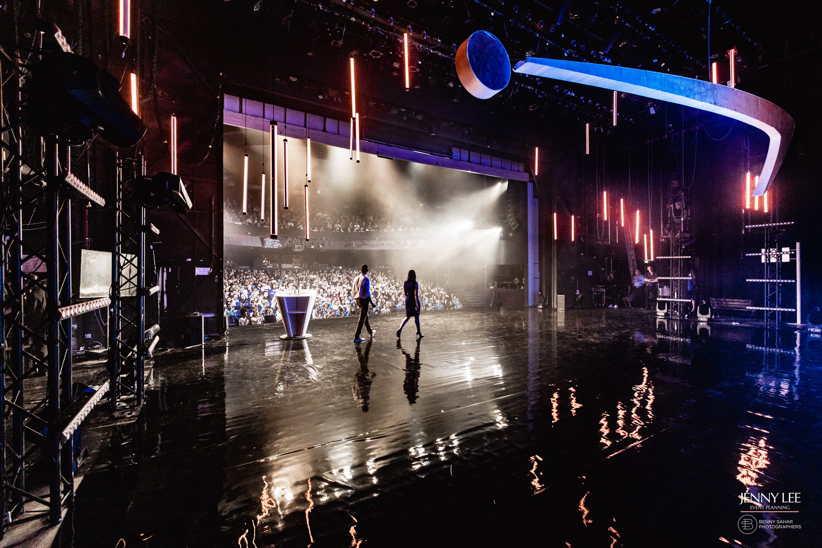 Large event stage with audience and dramatic lighting.
